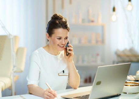 Ärztin am Schreibtisch mit Telefon und Laptop